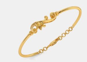 Delicate floral-inspired gold kada for a graceful look.